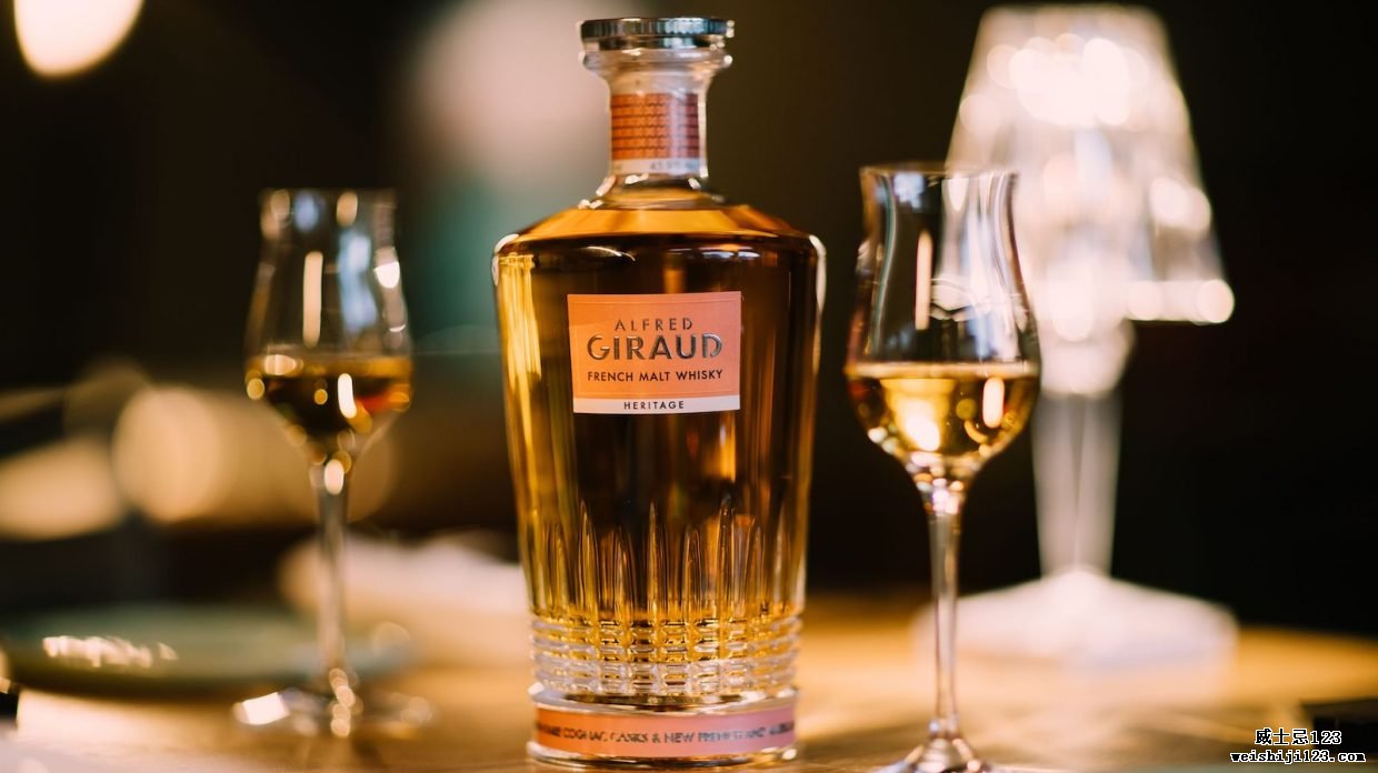 一瓶 Alfred Giraud Heritage 法国混合麦芽威士忌和两个高脚品酒杯。