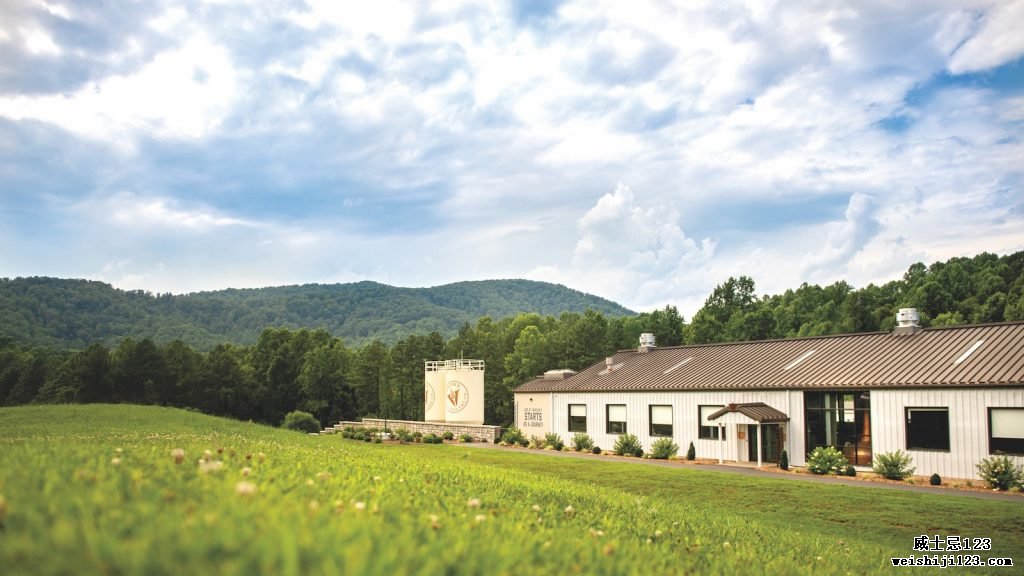 在微阴的天气里，弗吉尼亚酿酒厂公司坐落在一大片绿色的田野上。