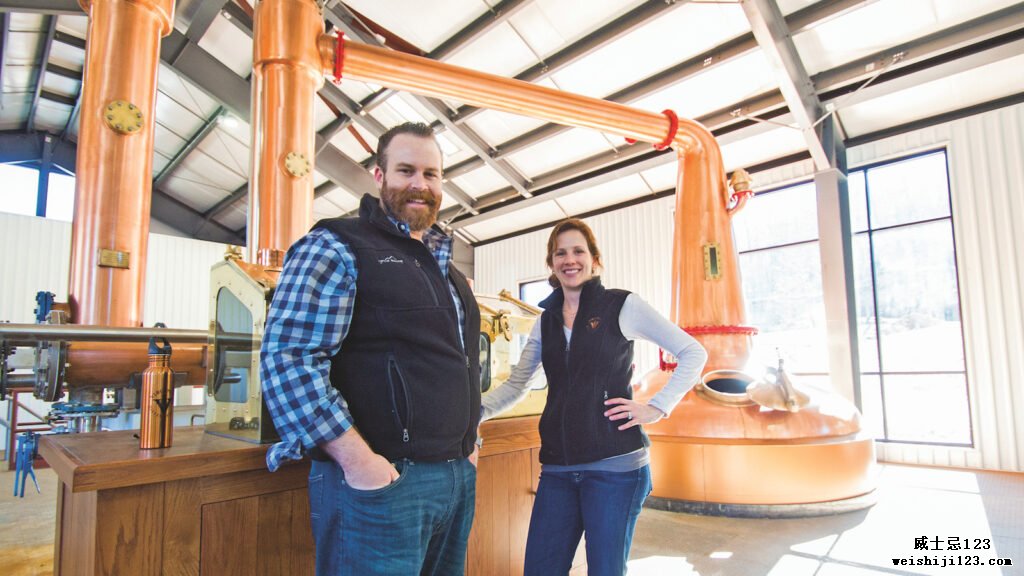 Virginia Distillery Co. 的老板 Gareth 和 Maggie Moore 在酒厂里，可以看到背景中的蒸馏器。